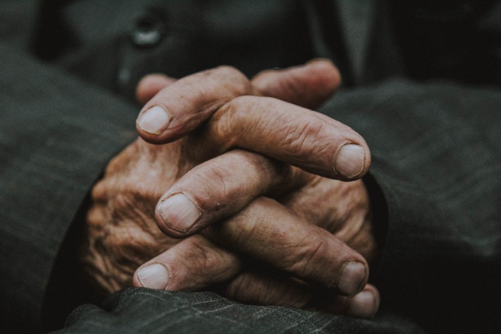 oude mannen handen in elkaar gevouwen